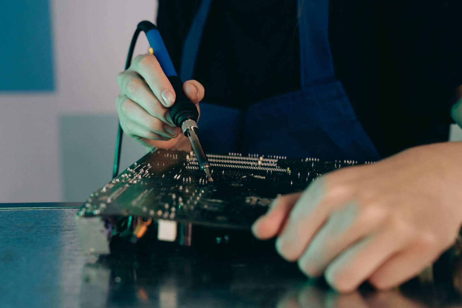 Técnico reparando una placa electrónica en el taller